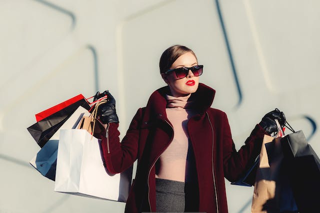 両手に買い物袋を抱える女性
